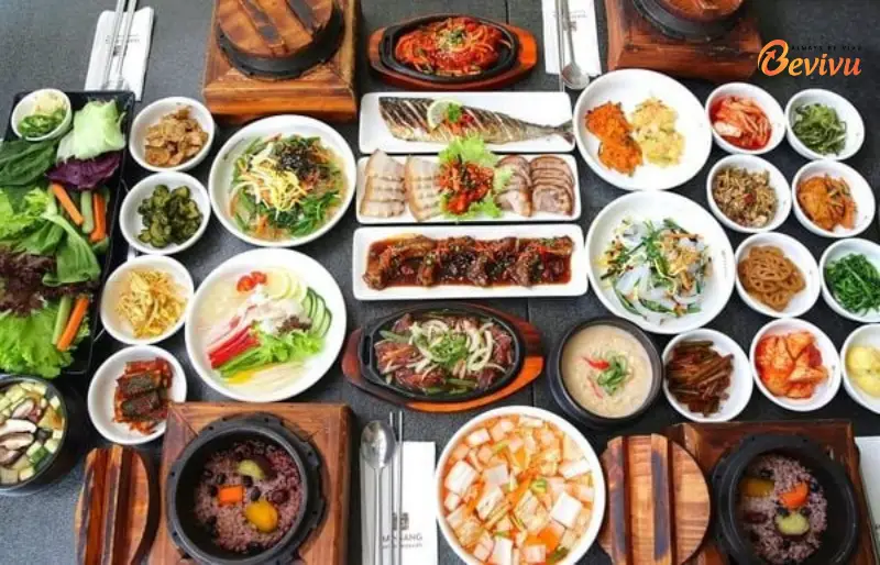 Một bàn ăn đầy đủ các món đặc sản Bắc Kinh như vịt quay, mì, và các món ăn đường phố
