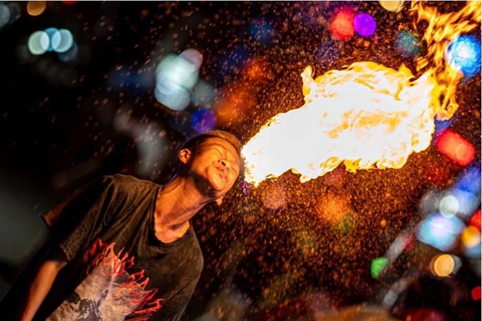 Con phố đông đúc về đêm với ánh đèn và người qua lại, giống như ở Bangkok