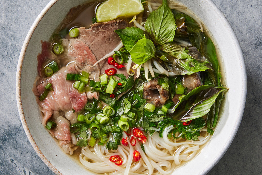 Bát phở bò tái với đầy đủ các loại gia vị và rau sống đi kèm