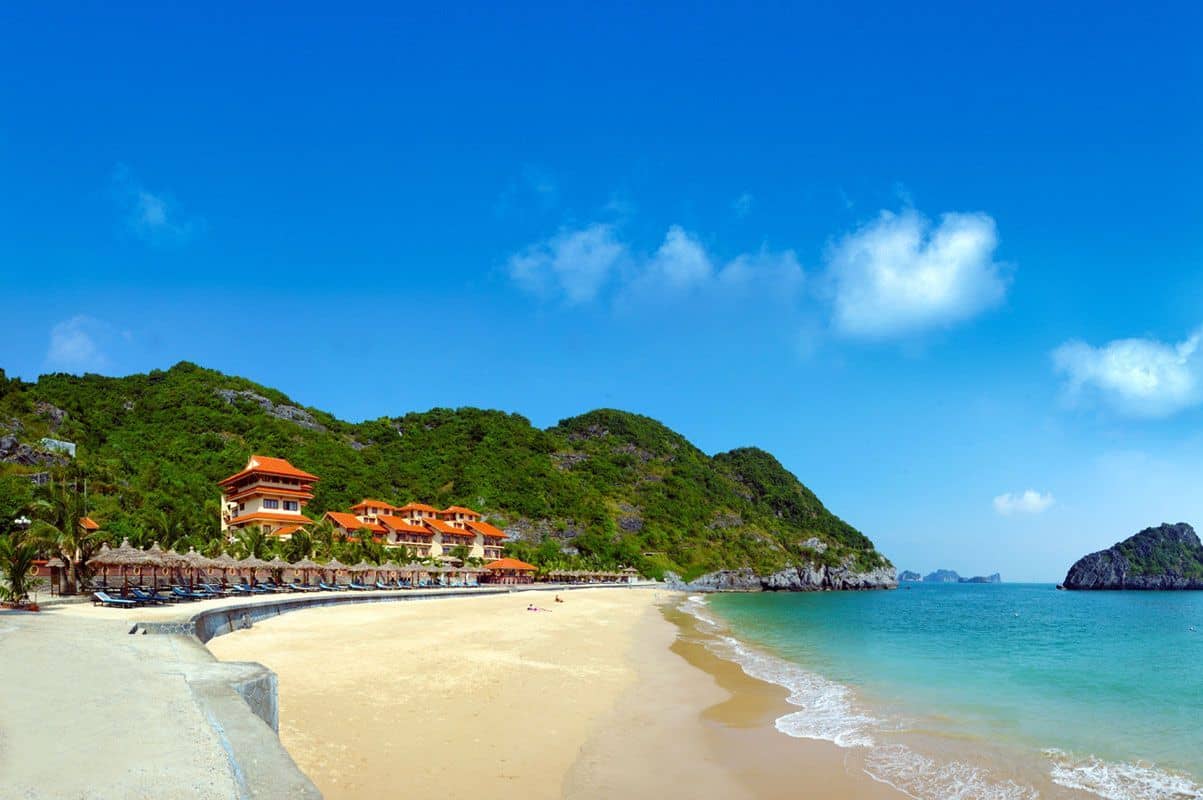 Bãi biển Đồ Sơn với cầu cảng vươn ra biển, mặt nước êm ả và những ngọn núi xa xa.