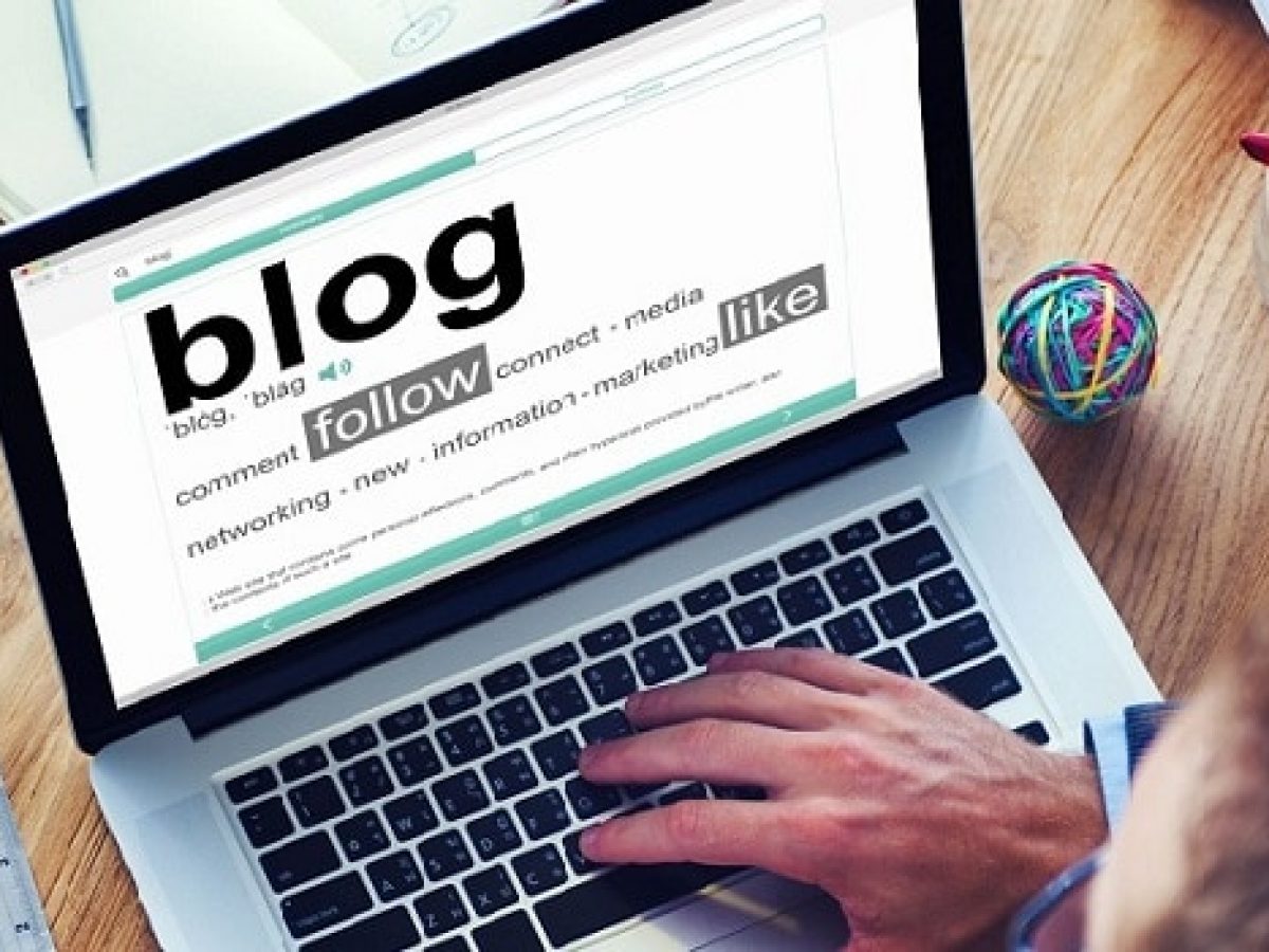 Một người đang gõ phím trên laptop, màn hình hiển thị trang blog, tượng trưng cho việc xây dựng và quản lý blog cá nhân.