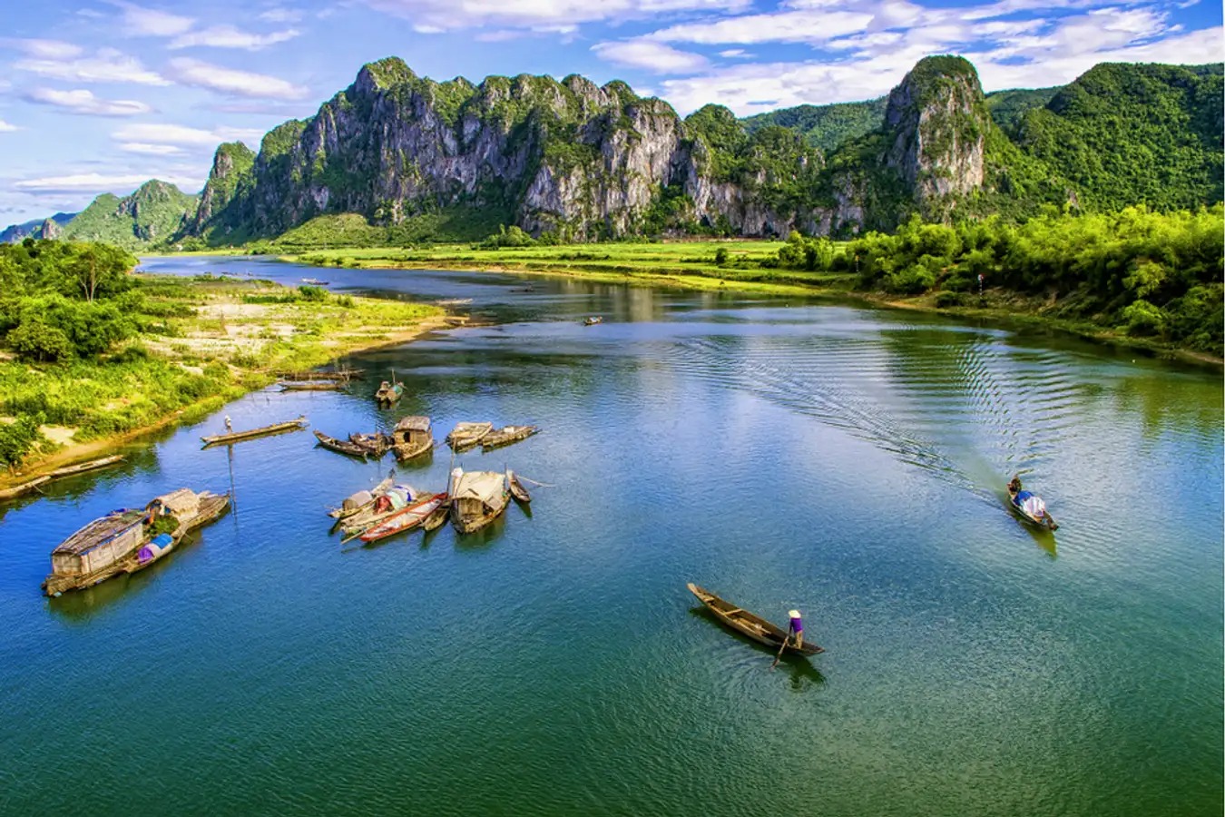 Đoàn tàu đang chạy qua một vùng nông thôn yên bình với cánh đồng xanh mướt
