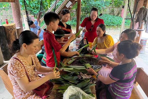 Cảnh mọi người quây quần bên mâm cơm ấm cúng, thưởng thức món ăn địa phương