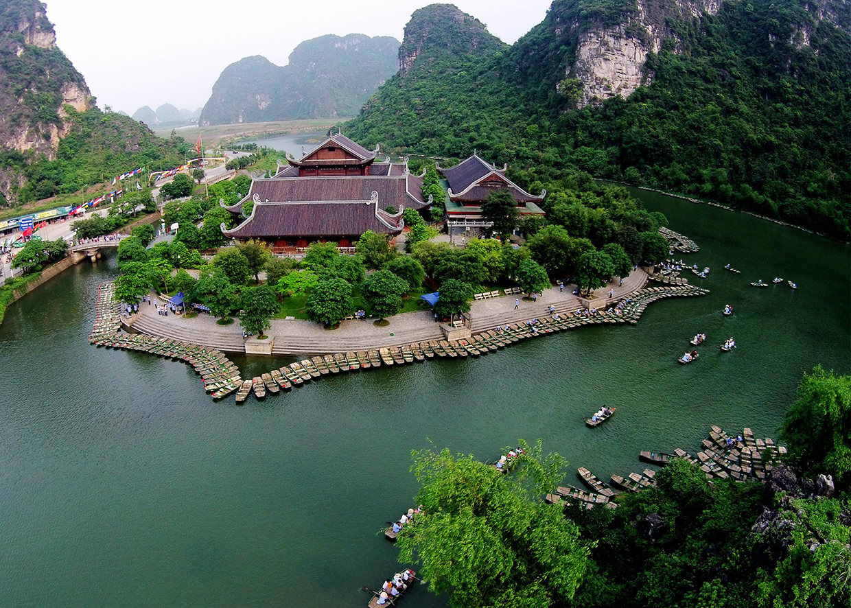 Hình ảnh một chiếc thuyền nhỏ đang chèo qua khu rừng ngập mặn, thể hiện hoạt động du lịch sinh thái.