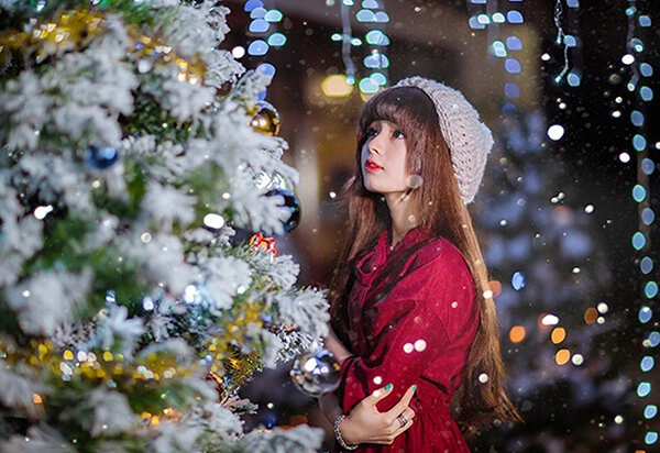 Cô gái chụp ảnh bên cây thông Noel tại Saigon Garden