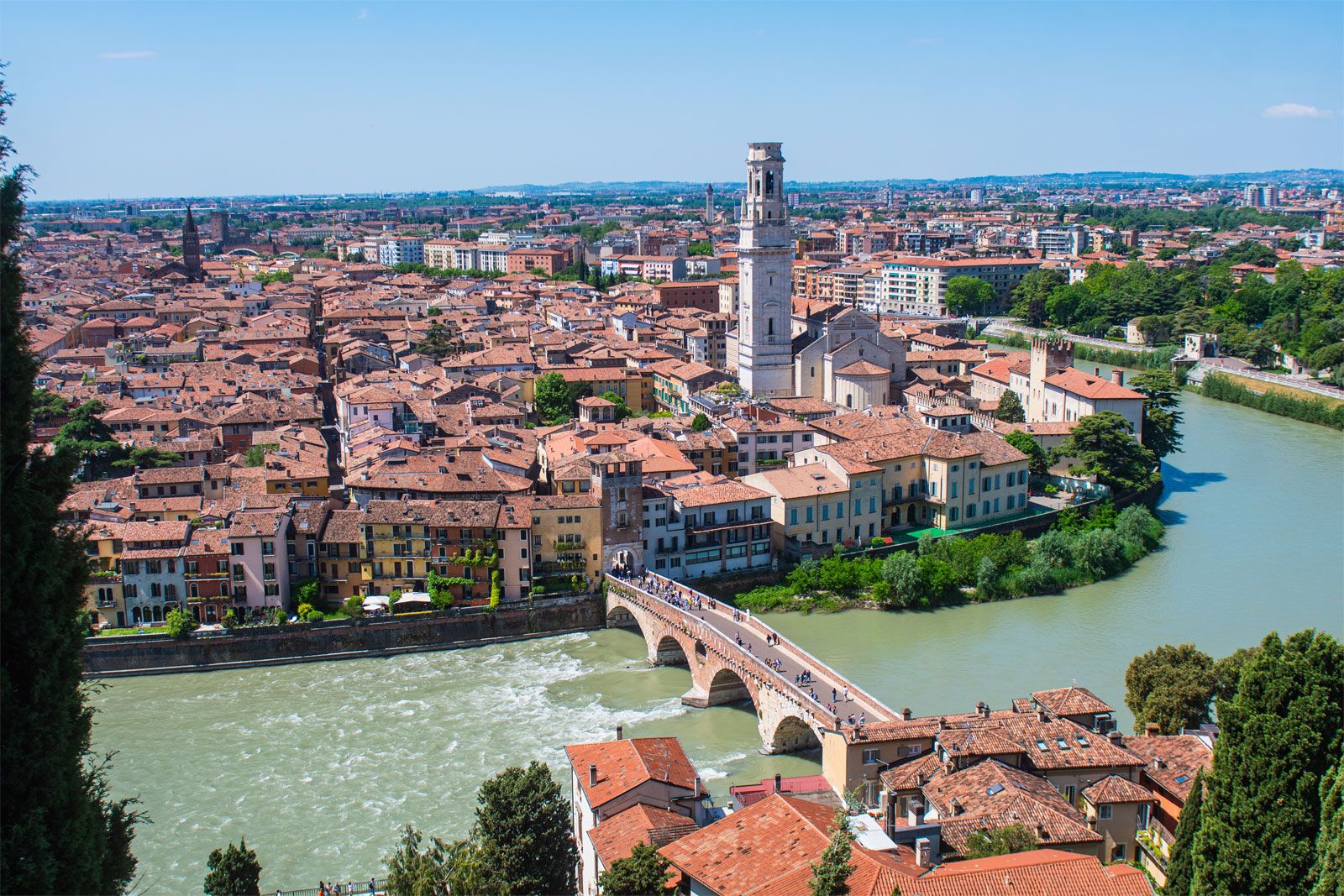 Cầu Ponte Pietra bắc qua dòng sông Adige xanh biếc, phía xa là những ngọn đồi và kiến trúc cổ của Verona
