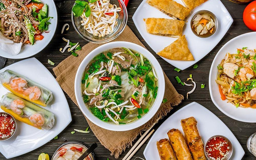 Một tô phở nóng hổi với thịt bò, hành lá và rau thơm